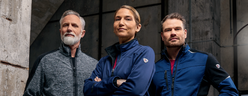 Deux hommes et une femme portent des vêtements de travail BP® dans un hall.